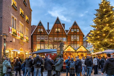 Christmas market or Christmas village at the Kiepenkerl memorial at dusk, Münster, North
