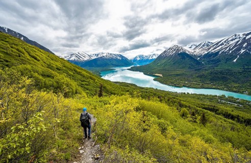Climbers on a hiking trail, Slaughter Ridge Trail, view of snowy mountains in spring and turquoise