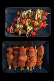 Meat and vegetable skewers in bowls on a black background, Bavaria, Germany