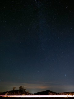 Milky Way stars, shining above the A44 motorway at night, the traffic headlights appearing as