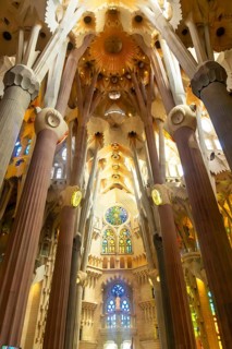 Interior view of the sagrada familia in barcelona, showing inclined columns and colorful stained