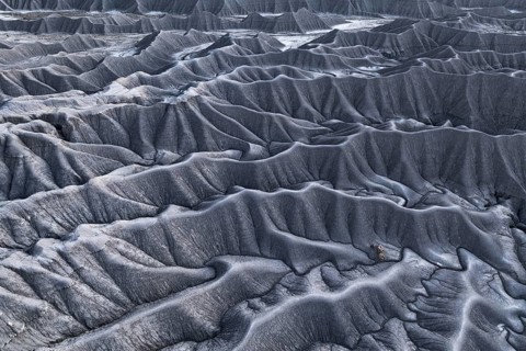 Expansive aerial view showcasing the unique and textured gray terrain of Caineville Mesa near