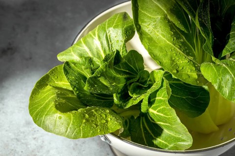 Close up of fresh bok choy leaves in natural light, showcasing vibrant green color and texture with