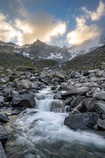 Mountain stream Furtschaglbach at sunrise, long exposure, rocky mountains behind, summit