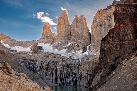 Impressive rock formations under a blue sky, surrounded by snow and waterfalls, the rock towers of