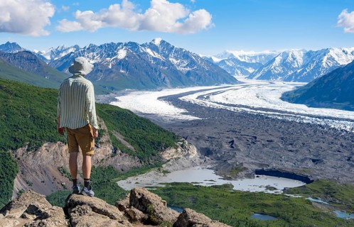 Young man enjoying the view, view of impressive mountain landscape with Matanuska glacier and