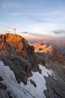 Summit of the Zugspitze with golden summit cross, alpenglow at sunset, Northern Limestone Alps,