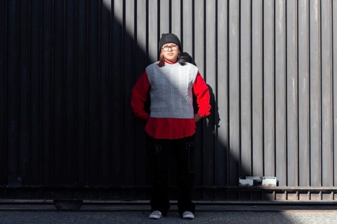 A young latina woman person stands confidently against a stylish, urban backdrop The modern outfit