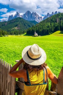 Tourist enjoying the breathtaking view of the st. Magdalena church with the odle mountains in the