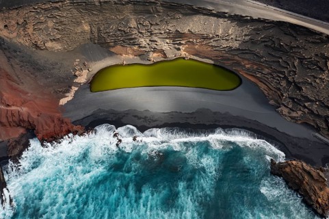 A spectacular aerial shot capturing the vibrant green lagoon of Los Clicos Beach contrasted against