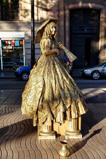 Street performer, mime, living statue of a golden lady with parasol, city centre, Barcelona, Spain