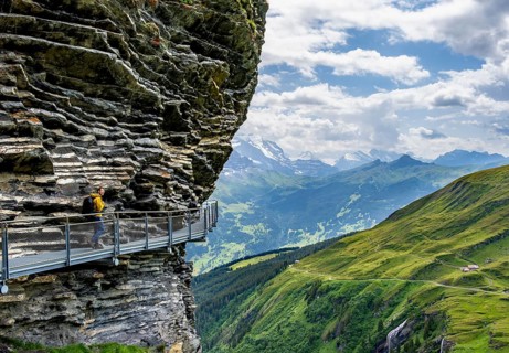Young man on First Cliff Walk, metal trail on a rocky outcrop, Grindelwald First, in front of