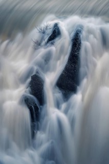 Ethereal view of water cascading over rocks in a long exposure shot, capturing the silky texture of