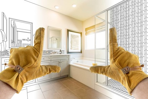 Male Contractor Hands Framing Completed Section of Bathroom Over Bathroom Drawing