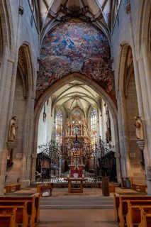 The magnificent carved altar made of linden wood with the choir arch fresco in Überlingen Münster,