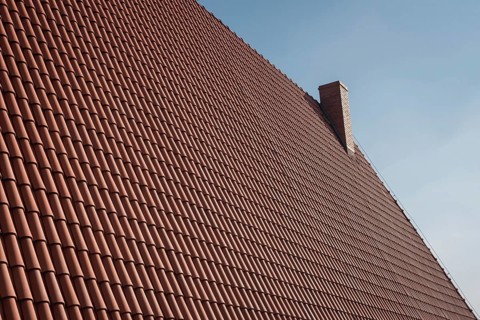 Roof with traditional polish tile and chimney in Poland