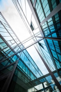 View of the sky between mirrored glass buildings reflecting blue and white, University of