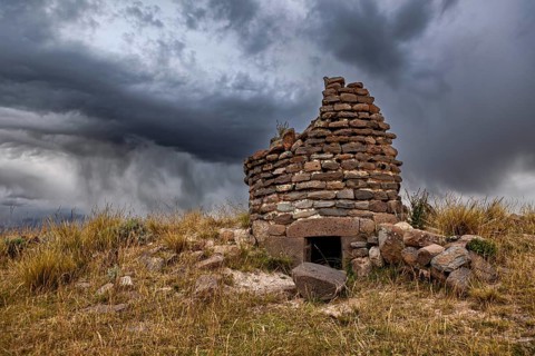 Abandoned stone ruin against dramatically cloudy sky, The Chullpas of Sillustani near Puno in Peru