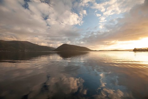 Golden hour light over the harbor and mountains. Summer sunset, Rosendal Port, Vestland, Norway