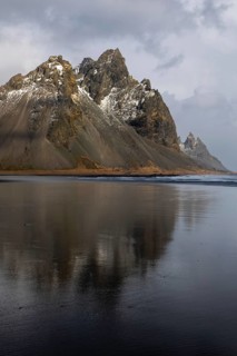 Reflection of Vestrahorn on black lava sandy beach, sea, winter, Stokksnes, Vestrahorn,