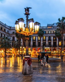 Nightlife at Plaça Reial, lanterns by Gaudi in the historic centre of Barcelona, Spain