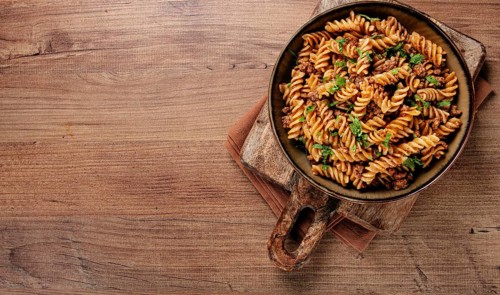 Pasta in the navy, pasta with minced meat, plate on a wooden table, homemade, fusilli pasta,