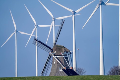 Poldermolen De Goliath windmill stands between the high-tech wind turbines in Eemshaven, historic