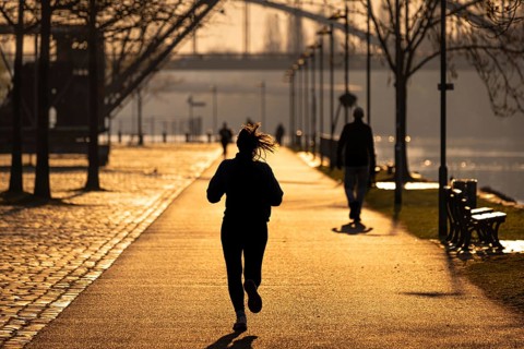 Joggers run along the banks of the Main in Frankfurt in the morning just after sunrise, Frankfurt
