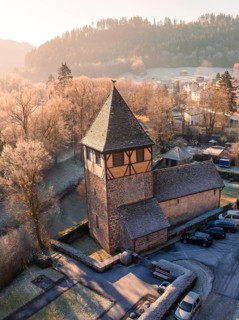 Historic half-timbered church tower in the village, surrounded by frozen trees in the soft morning