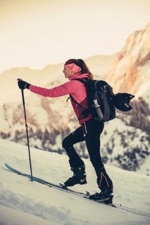 A woman's ski tour at sunrise on the Tegelberg in the Allgäu in the Ammergebirge, Bavaria, Germany