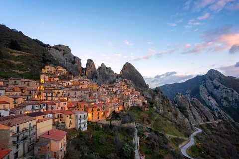 The enchanting village of Castelmezzano, nestled in the Lucanian Dolomites, glows under a vibrant