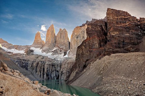 Rocky ridges and snow above a lake in a remote valley, The rock towers of Torres del Paine in