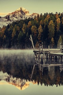 Lake Staz near Sankt Moritz in the Engadin in Switzerland. Morning atmosphere with fog in autumn.