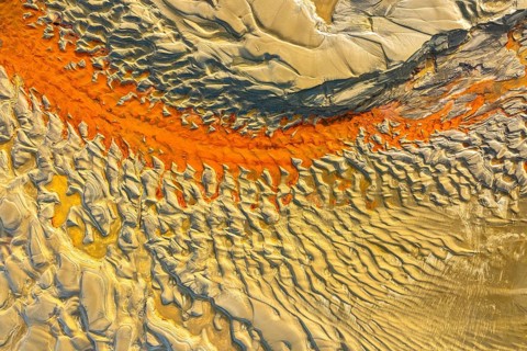Aerial capture of sand patterns showcasing vivid colors and intricate designs. The interplay of