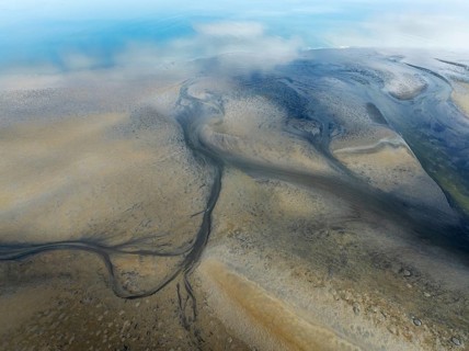 Streams and marshes at low tide in the coastal wetlands of the Walvis Bay lagoon. Aerial view.