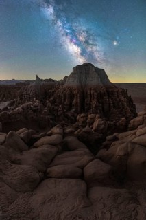 A stunning view of the Milky Way arching over the intriguing rock formations of Goblin Valley State