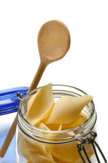 Conchiglione in glass jar with cooking spoon, Italian pasta variety