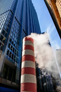 Steaming chimney at a construction site behind a skyscraper, New York City, USA