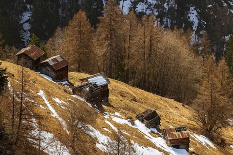 Ruined haybarn built on the hillside surrounded by remnants of snow, Chandolin, Val d'Anniviers,