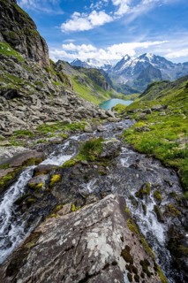 Mountain stream in picturesque mountain landscape, view of mountain lake Lac du Louvie and