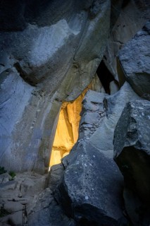 Incidental sun illuminates the passage (Chambre du Roi) through the high rocks, hike through the