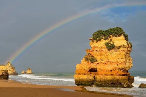 Rocks on beach with rainbow, Praia Dona Ana, Lagos, Algarve, Portugal