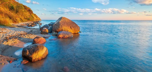 Coastal landscape with large boulders on the Baltic Sea beach in the evening light, Mönchgut Nature