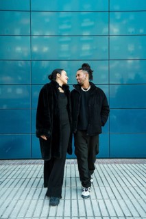 A multicultural couple walks closely, showcasing diversity and unity. The man and woman share a