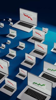Laptops in a modern office show fluctuating stock trends, reflecting the dynamic nature of