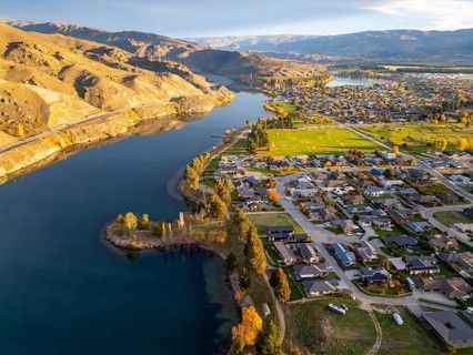 Aerial view of Queenstown during autumn, showcasing vibrant foliage and a lake, stunning landscapes