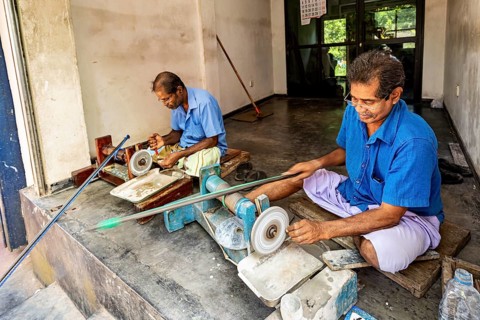 In the workshop two men work on machines with care and precision, the gemstone cutters in the city
