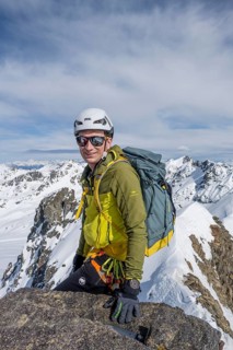 Mountaineer on the summit of Piz Grialetsch in winter, view of mountain panorama with snow, Grisons