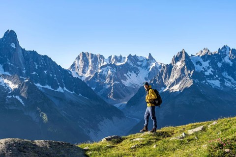 Young man in front of impressive mountain landscape in morning light, picturesque mountain