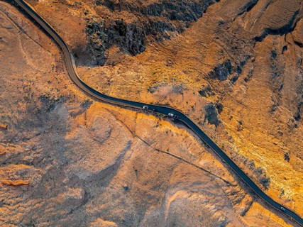 Road on cliffs in evening light, steep cliffs on the coast near Mirador del Porrito, aerial view,